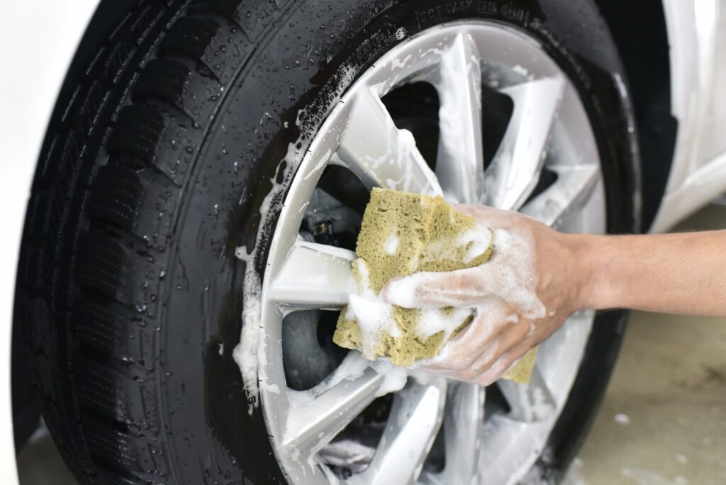 Car cleaning, man cleaning car, washing the alloy wheel