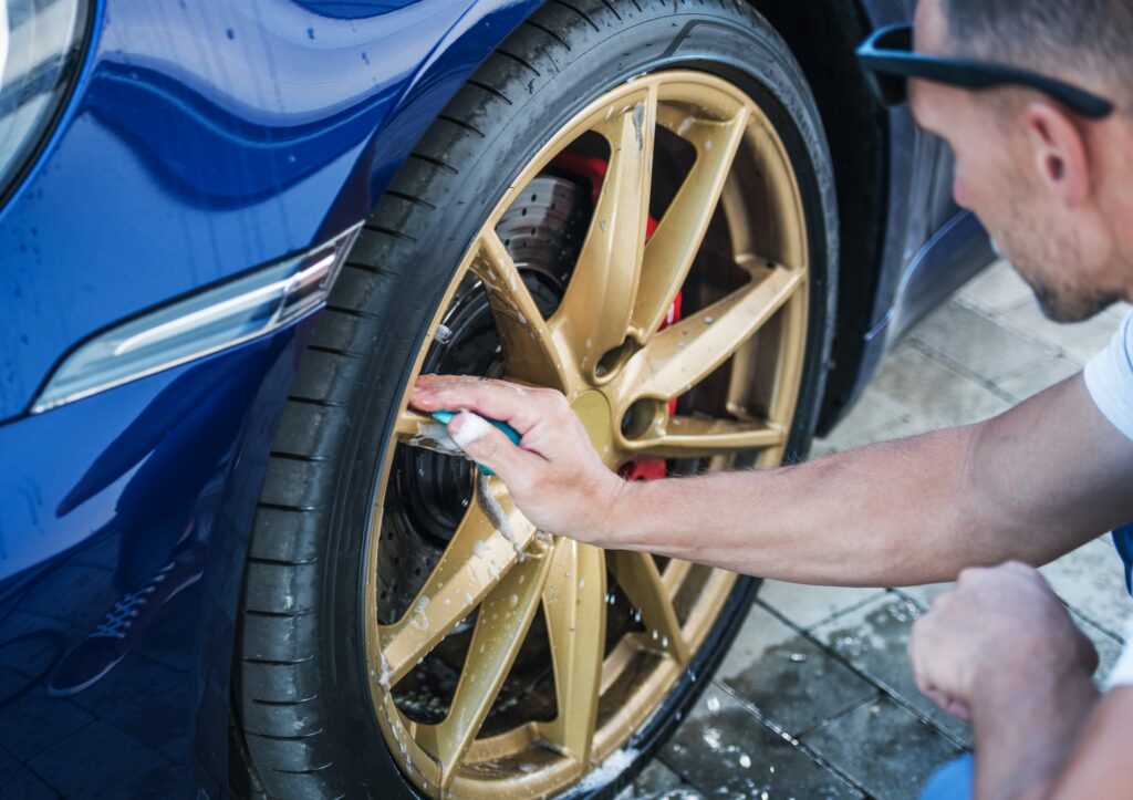 Men Cleaning Alloy Wheels of His Car