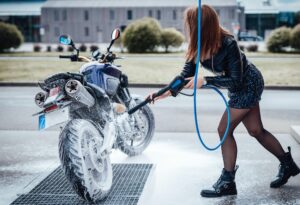Woman washing her urban bike in carwash