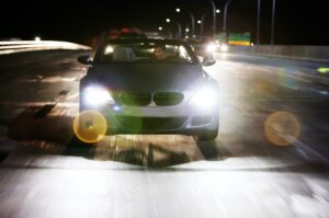 Man Driving Car On Illuminated Street At Night