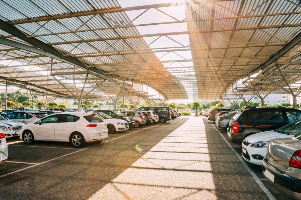 Cars on a covered parking lot in sunny summer day