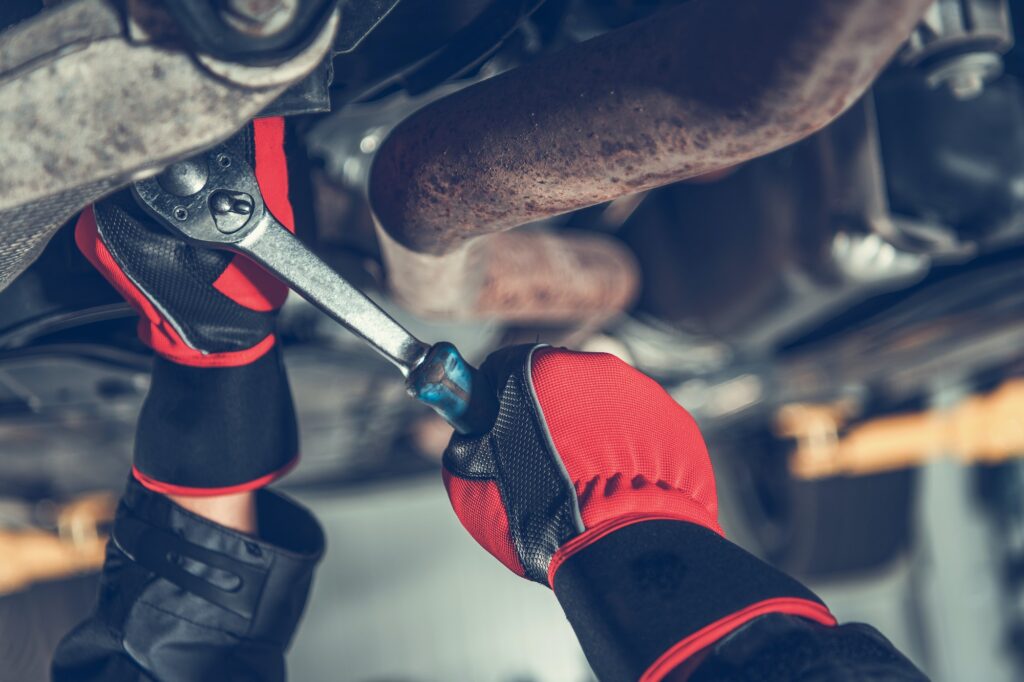 Car Mechanic Repairs Modern Vehicle Suspension Element