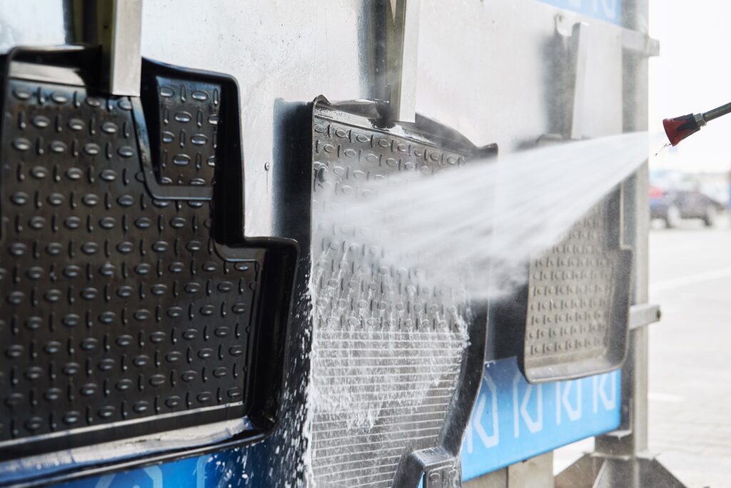Cleaning car mat with high pressure water at car wash station