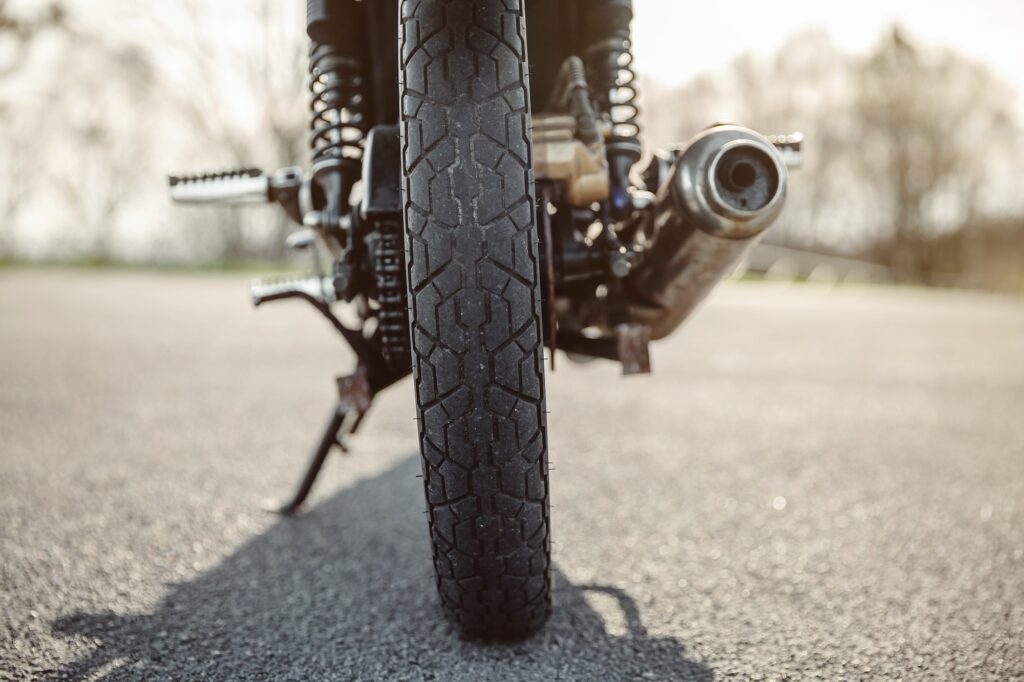 Wheel and exhaust pipe of motorcycle on road
